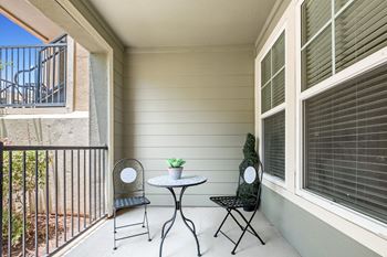 A patio with two chairs and a table on a balcony
